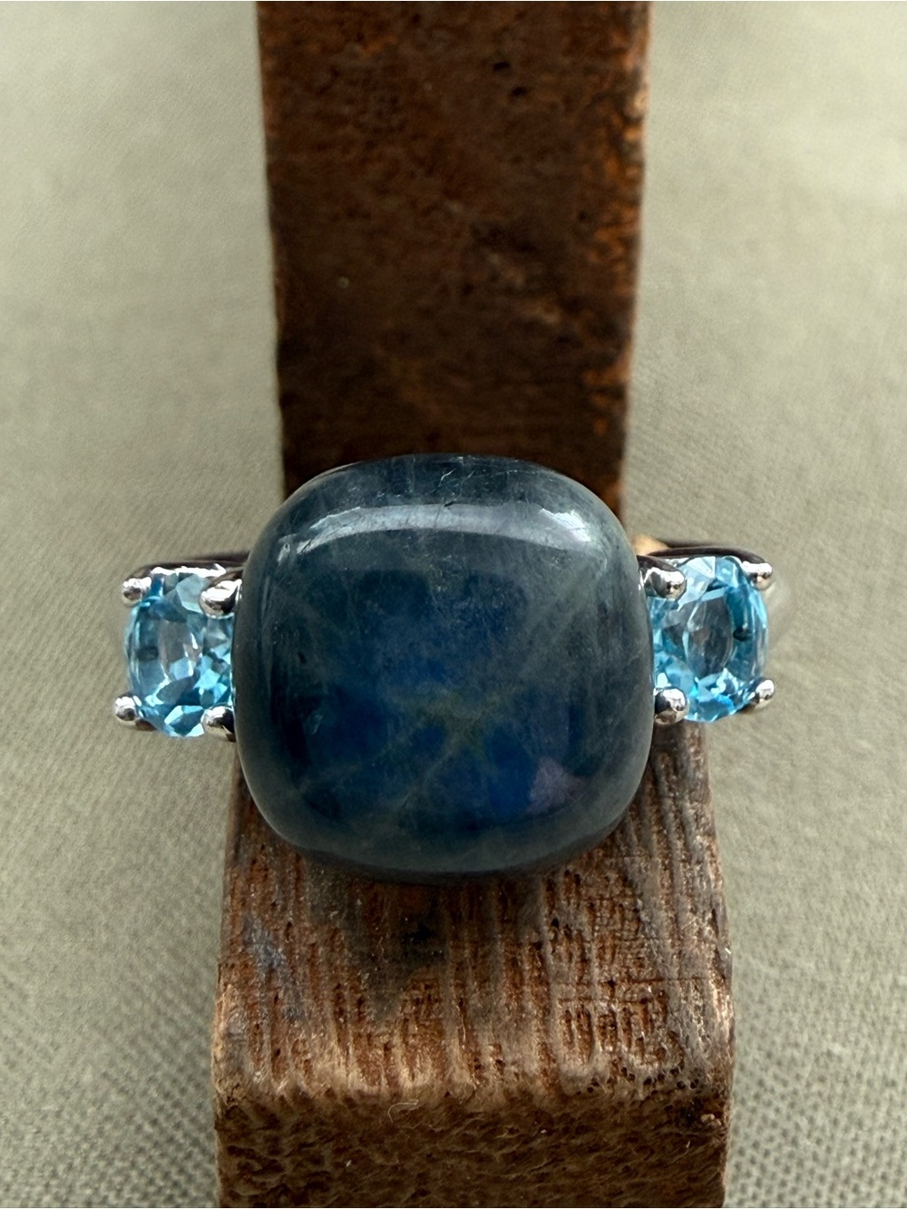 Blue Cushion Centerstone Ring with Sky Blue Side Gemstones.